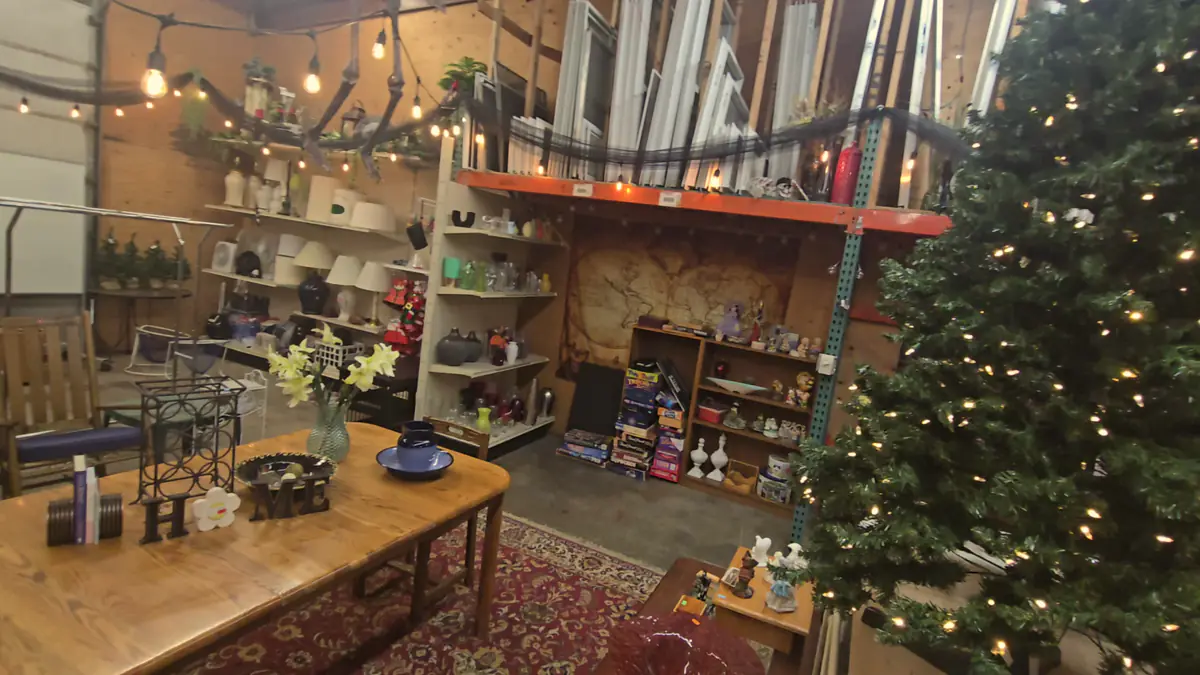 A decorated Christmas tree beside tables of finds